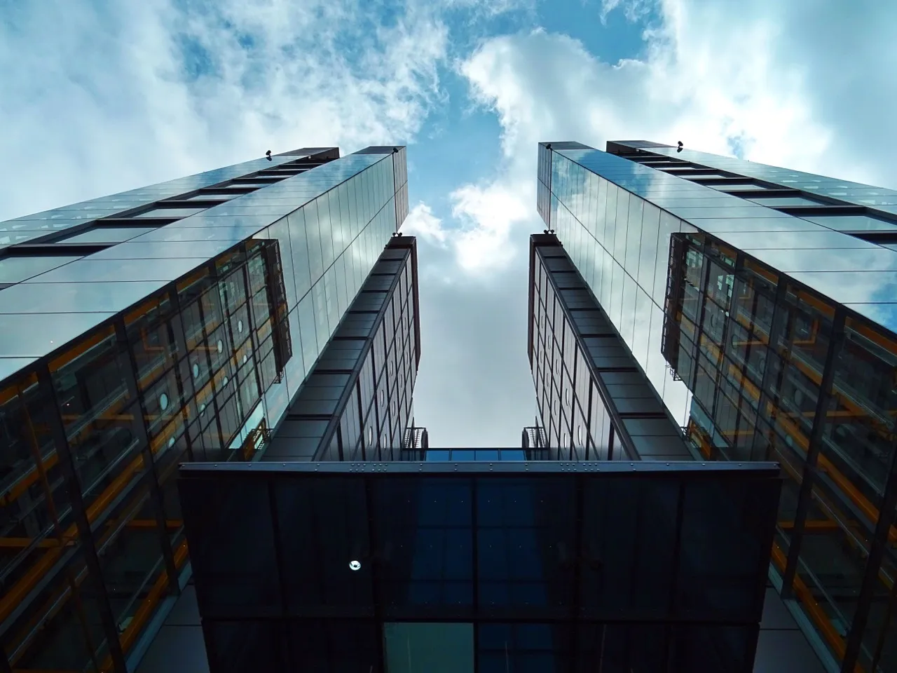 Two tall buildings with numerous windows stand against a clear blue sky, creating a striking urban skyline.